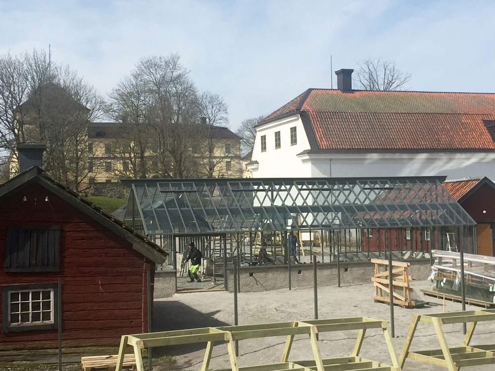 En kvinna stänger växthusdörr