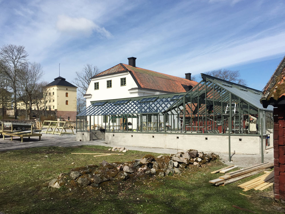En kvinna stänger växthusdörr