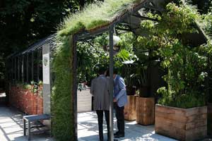 Två besökare som diskuterar i en visningsträdgård producerad av Gally på den franska trädgårdsmässan Jardins jardin