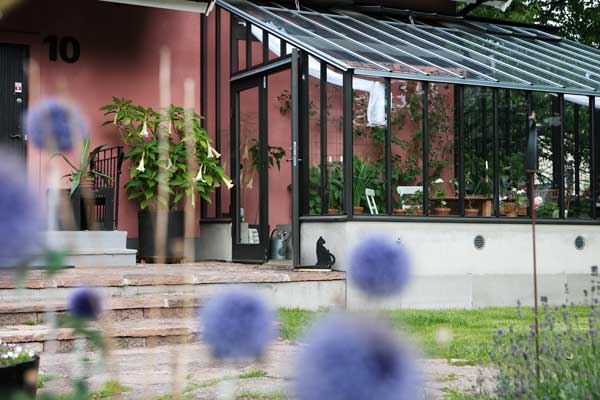 svart växthus mot en rosa vägg
