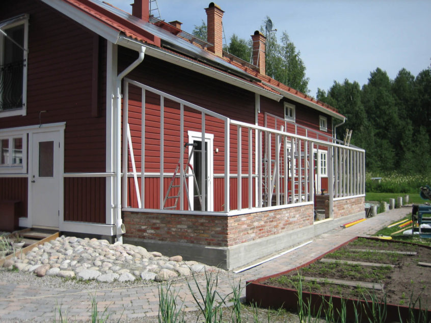 Bygge av vitt växthus mot hus