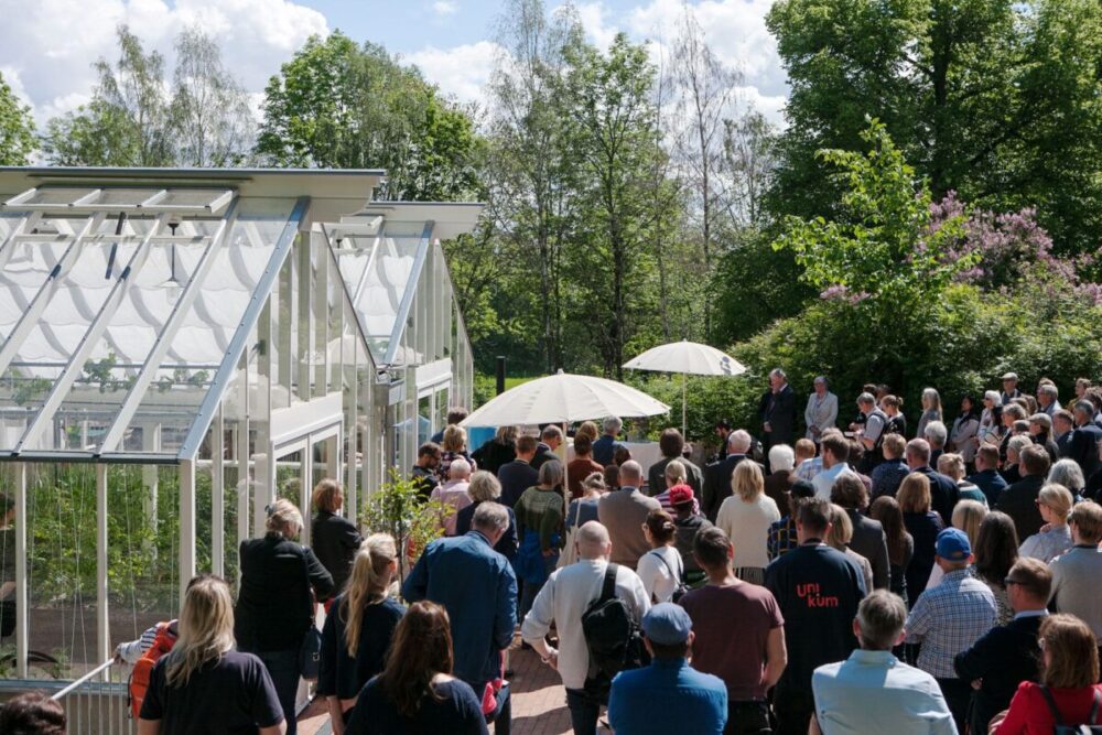 Folksamling framför ett stort växthus