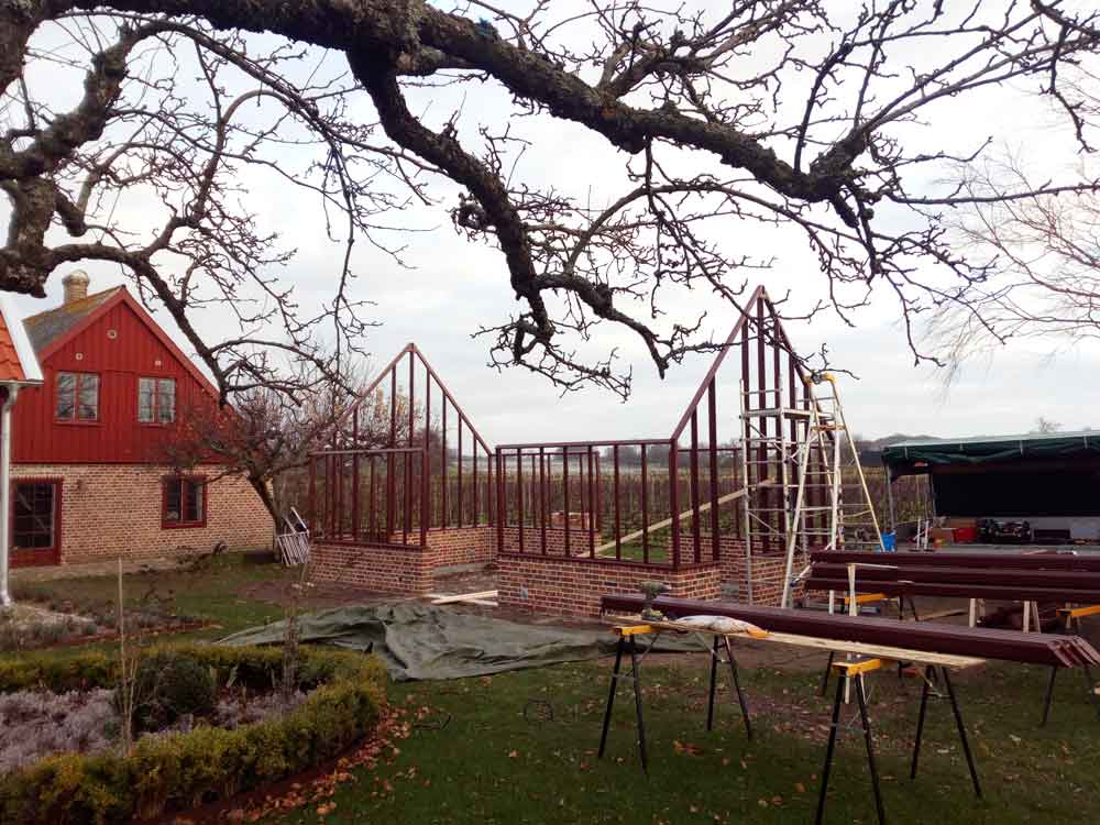 Rött växthus med sadeltak.