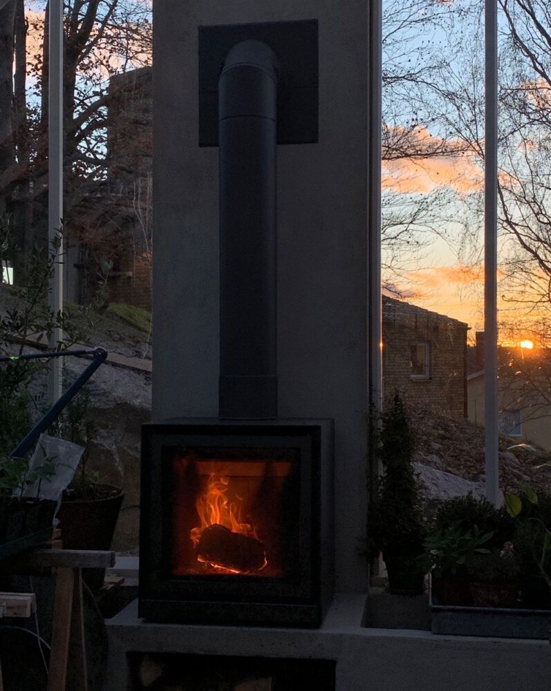 Öppen spis i solnedgång i växthus.