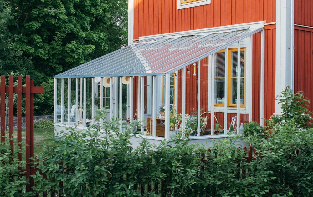 Ett vitt växthus med pulpettak.