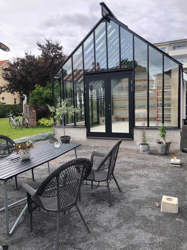 Ett bord med stolar framför ett växthus