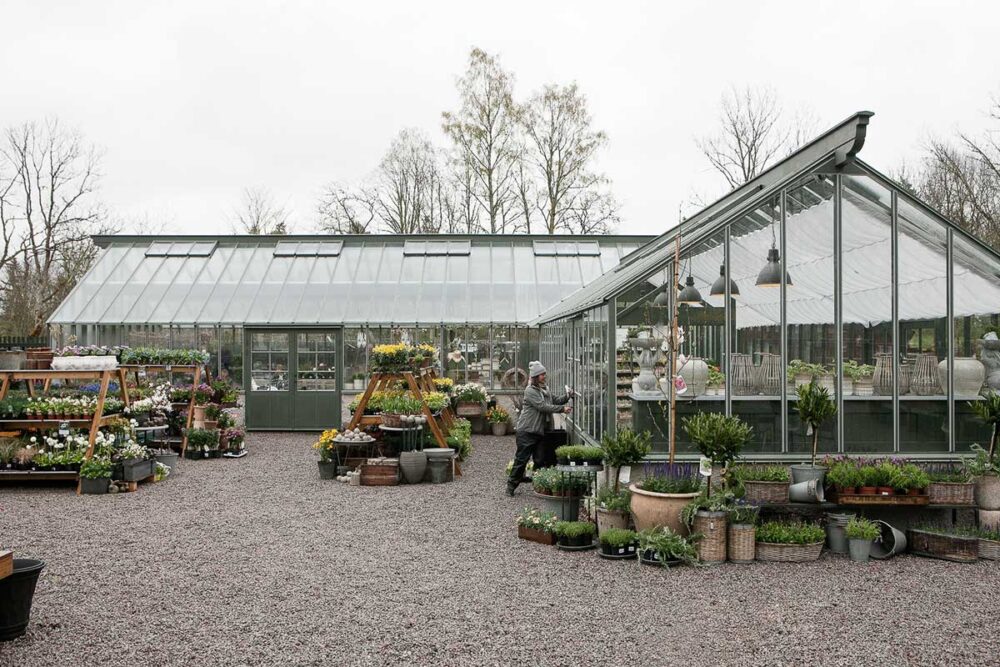 En kvinna stänger växthusdörr