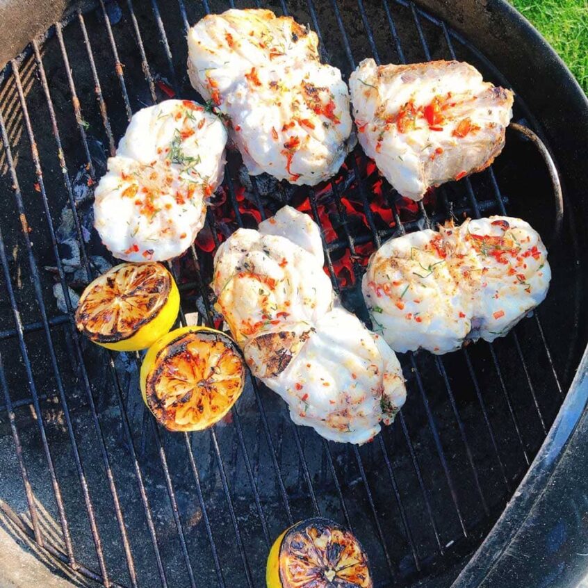 Fisk och citroner på utegrill.