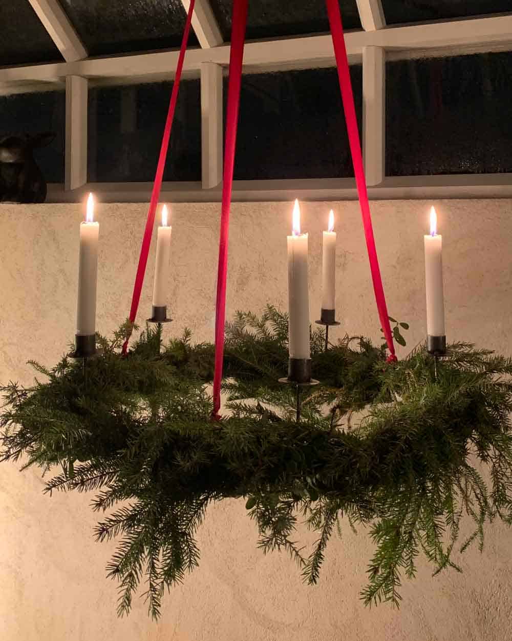 Tän granklädd ljuskrona med röda band.