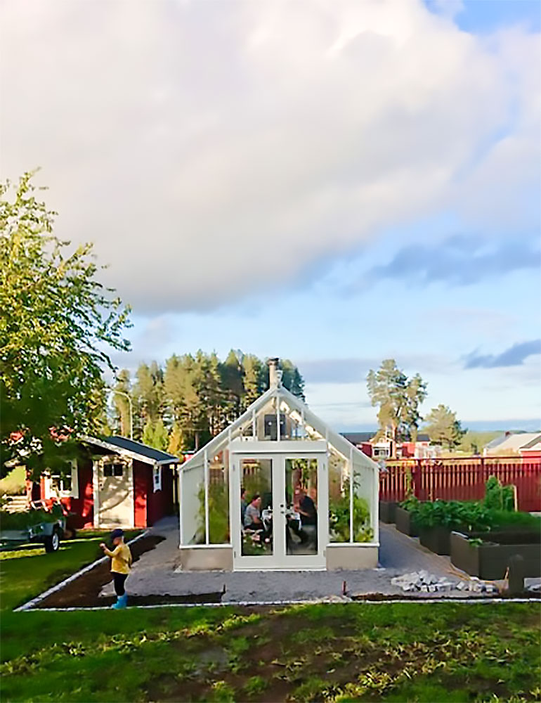 ett vitt växthus på tomten